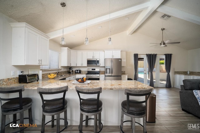 1109 Bell Ave, Taft, CA 93268 - kitchen featuring appliances with stainless steel finishes, a peninsula, white cabinetry, ceiling fan, and open floor plan