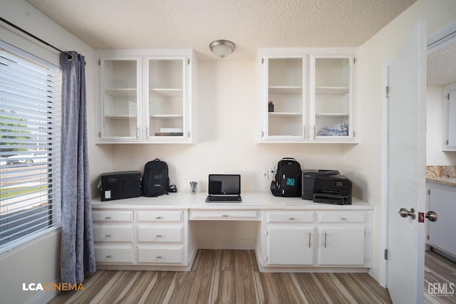 1109 Bell Ave, Taft, CA 93268 - home office with built in desk, light wood-style floors, and a textured ceiling
