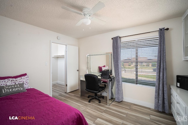 1109 Bell Ave, Taft, CA 93268 - bedroom with light wood-style floors, baseboards, a textured ceiling, ceiling fan, and an office area