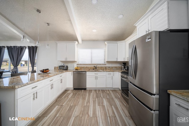 1109 Bell Ave, Taft, CA 93268 - kitchen with stainless steel appliances, a sink, a peninsula, a textured ceiling, and white cabinets