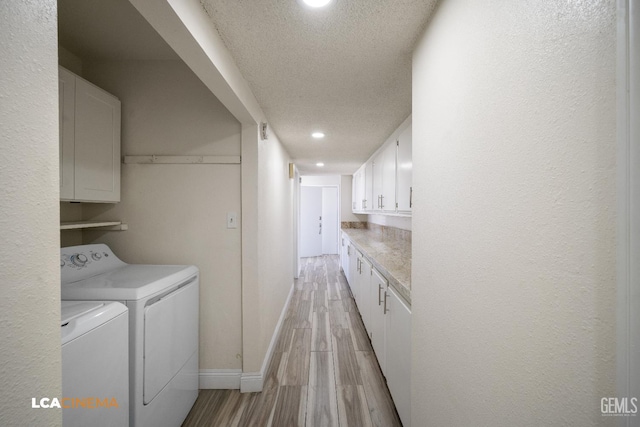 1109 Bell Ave, Taft, CA 93268 - laundry area with washer and clothes dryer, baseboards, a textured ceiling, light wood-type flooring, and cabinet space