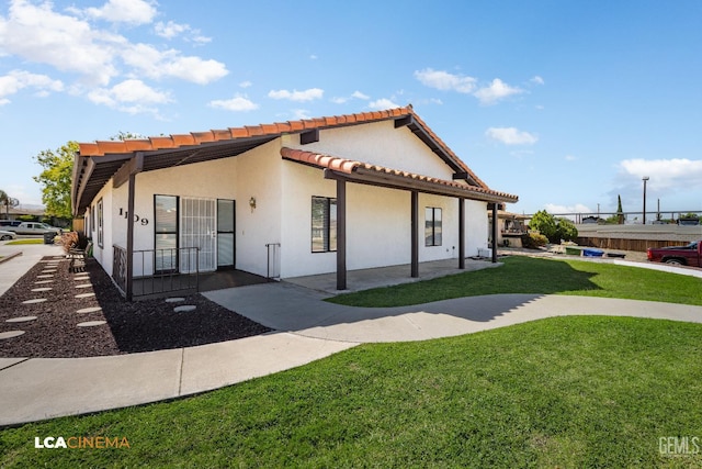 1109 Bell Ave, Taft, CA 93268 - mediterranean / spanish house featuring a front yard, stucco siding, and a tiled roof