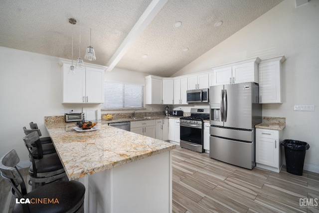1109 Bell Ave, Taft, CA 93268 - kitchen featuring stainless steel appliances, a sink, a textured ceiling, a peninsula, and a breakfast bar