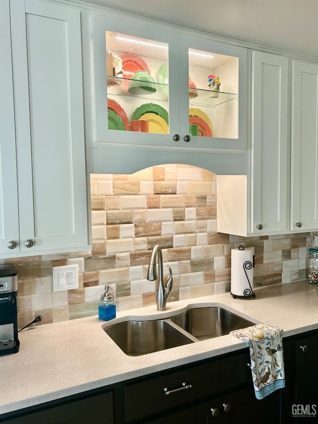 kitchen with decorative backsplash, sink, and white cabinetry