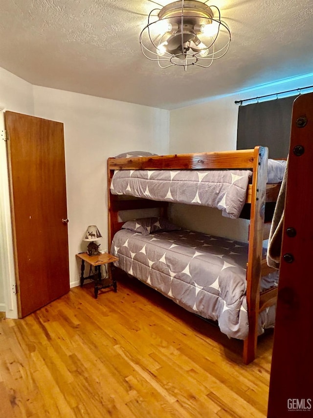 bedroom featuring a textured ceiling and hardwood / wood-style flooring