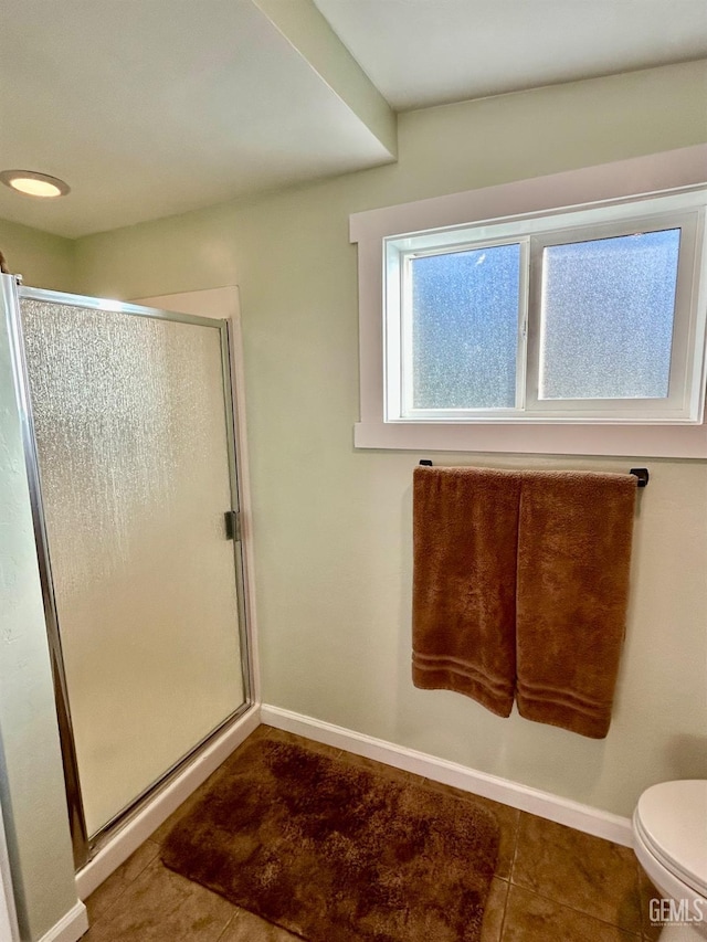 bathroom featuring tile patterned floors, a shower with door, and toilet