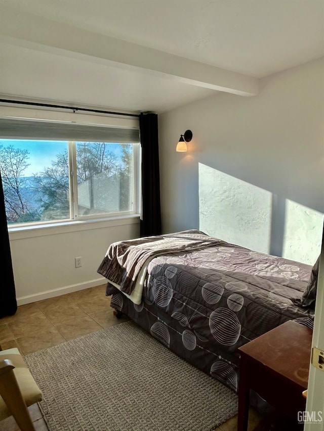 tiled bedroom featuring beam ceiling