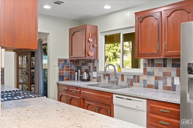 253 E Mckee Rd, Bakersfield, CA 93307 - kitchen with white dishwasher, stainless steel fridge, decorative backsplash, light stone counters, and recessed lighting