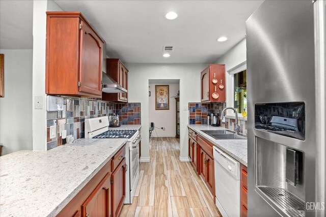 253 E Mckee Rd, Bakersfield, CA 93307 - kitchen with white appliances, backsplash, recessed lighting, light wood finished floors, and wall chimney range hood