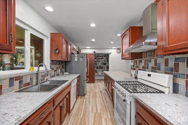 253 E Mckee Rd, Bakersfield, CA 93307 - kitchen with white appliances, wall chimney range hood, a barn door, recessed lighting, and decorative backsplash