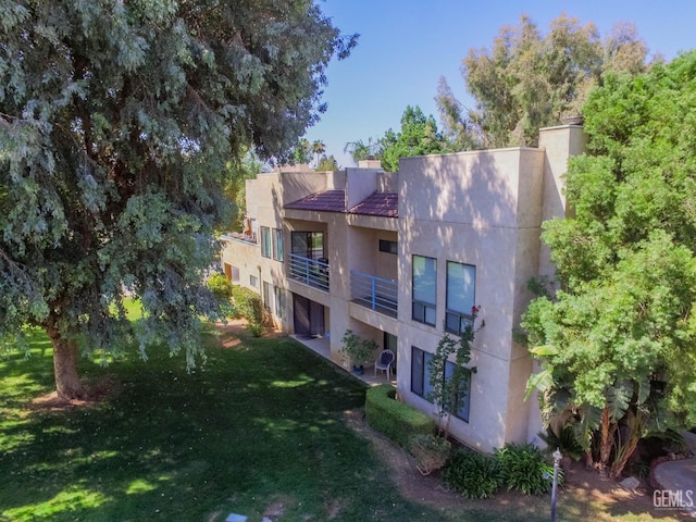14500 Las Palmas Dr Unit 3, Bakersfield, CA 93306 - rear view of property featuring stucco siding, a balcony, and a lawn