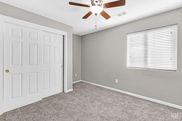 unfurnished bedroom with ceiling fan, light carpet, and a closet