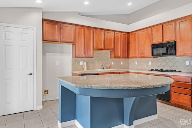 kitchen with light stone countertops, vaulted ceiling, sink, stainless steel gas stovetop, and light tile patterned flooring