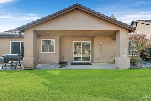 back of house with a patio area and a yard