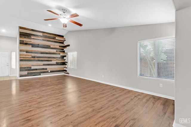 unfurnished living room with wood-type flooring, ceiling fan, and lofted ceiling