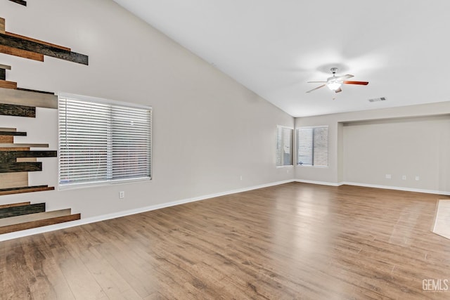 unfurnished living room featuring ceiling fan, wood-type flooring, and lofted ceiling