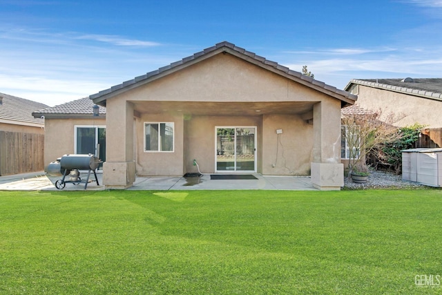 rear view of property featuring a patio area and a lawn