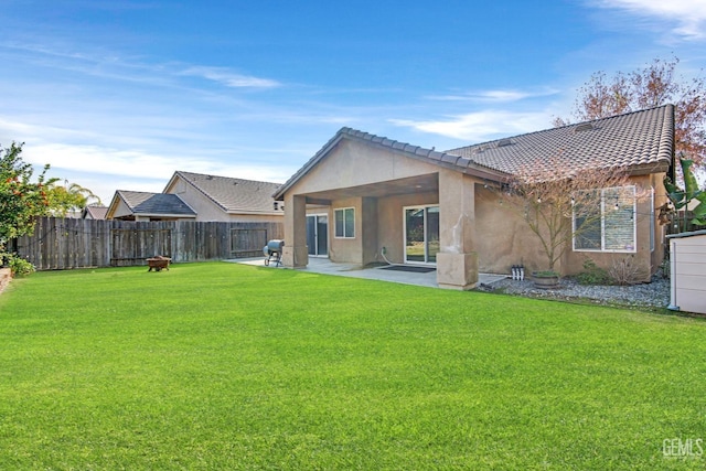 back of house featuring a patio area and a yard