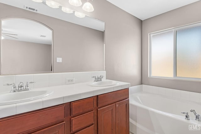 bathroom featuring a bath, vanity, and ceiling fan