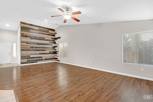 unfurnished room with hardwood / wood-style flooring, ceiling fan, and lofted ceiling