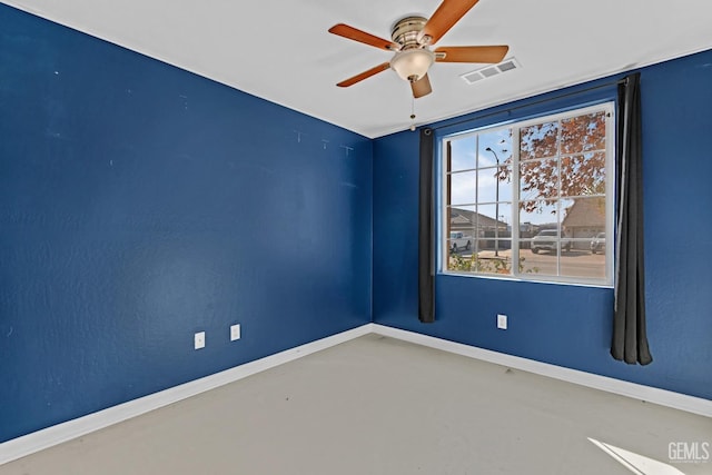 empty room with ceiling fan and concrete flooring