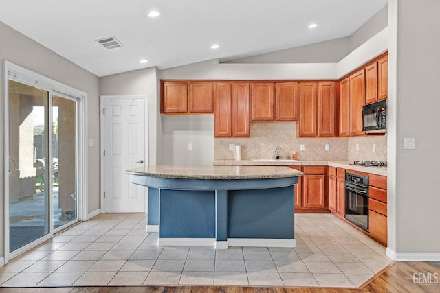 kitchen featuring sink, vaulted ceiling, a kitchen island, and black appliances