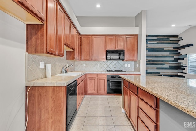 kitchen featuring light stone countertops, tasteful backsplash, sink, black appliances, and light tile patterned flooring