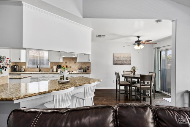 5812 Seasons Valley Ct, Bakersfield, CA 93313 - kitchen with decorative backsplash, white cabinets, dark wood-type flooring, a ceiling fan, and light stone countertops