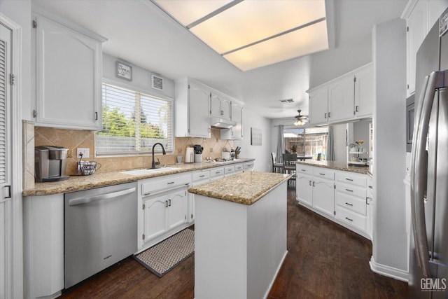 5812 Seasons Valley Ct, Bakersfield, CA 93313 - kitchen with appliances with stainless steel finishes, dark wood-type flooring, white cabinets, and decorative backsplash