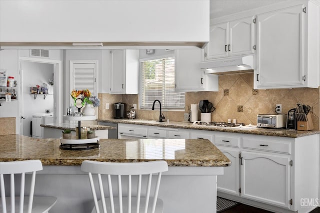 5812 Seasons Valley Ct, Bakersfield, CA 93313 - kitchen featuring under cabinet range hood, white cabinets, decorative backsplash, and light stone countertops