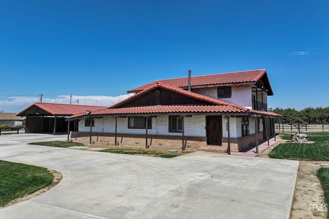 12606 Stradley Ave, Mc Farland, CA 93250 - view of front facade with stucco siding, driveway, a carport, brick siding, and a tile roof
