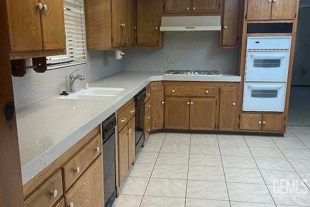 12606 Stradley Ave, Mc Farland, CA 93250 - kitchen with range hood, double oven, stainless steel gas stovetop, light countertops, and light tile patterned flooring