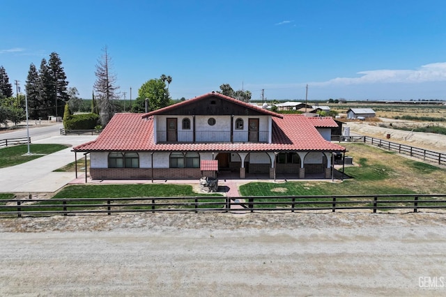 12606 Stradley Ave, Mc Farland, CA 93250 - mediterranean / spanish-style house featuring a tile roof, brick siding, and an exterior structure