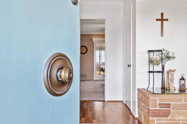 hallway with dark hardwood / wood-style flooring and crown molding