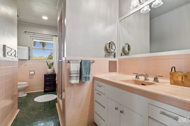 bathroom with vanity, toilet, and tile walls