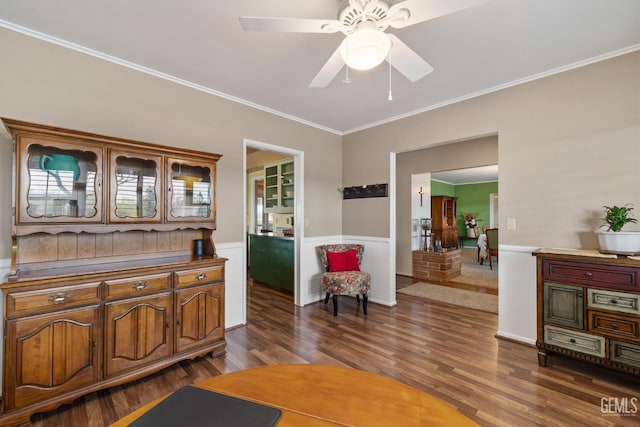 living area featuring dark hardwood / wood-style floors, ceiling fan, and crown molding