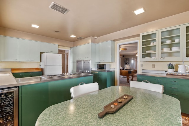 kitchen with white cabinetry, stainless steel appliances, and beverage cooler