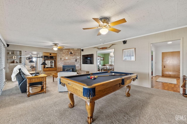 playroom with a wood stove, ceiling fan, billiards, crown molding, and light carpet