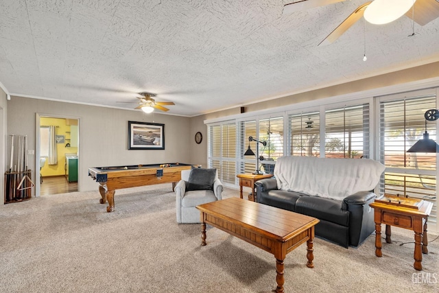 carpeted living room featuring ceiling fan, ornamental molding, a textured ceiling, and pool table