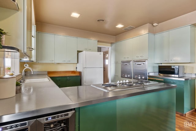 kitchen with white cabinetry, sink, stainless steel appliances, and stainless steel counters