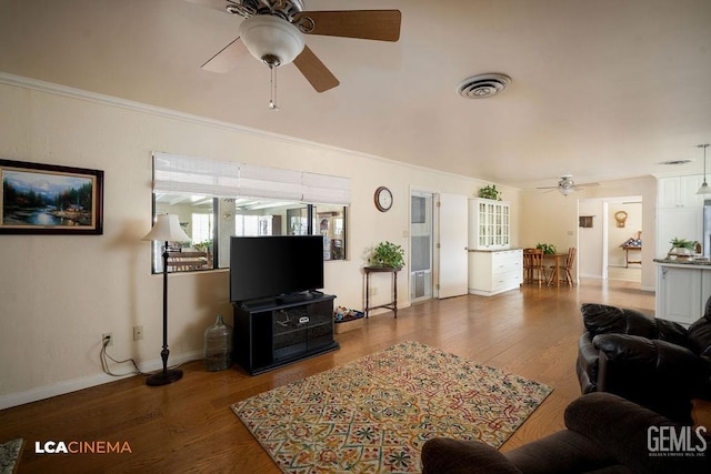 living room featuring crown molding, hardwood / wood-style flooring, and ceiling fan