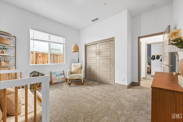 bedroom featuring a crib and light carpet