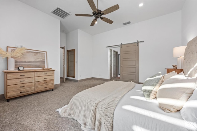 bedroom featuring light carpet, a barn door, and ceiling fan