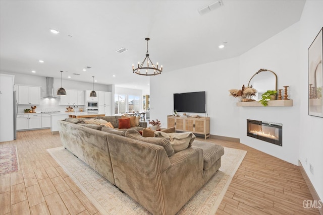 living room featuring a notable chandelier and light hardwood / wood-style flooring