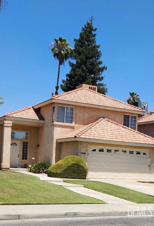 6308 Ambergrove St, Bakersfield, CA 93313 - view of front of property with an attached garage, concrete driveway, stucco siding, and a tiled roof