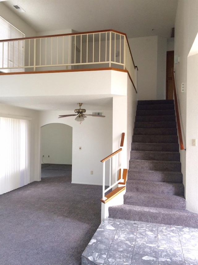 6308 Ambergrove St, Bakersfield, CA 93313 - staircase featuring ceiling fan, arched walkways, carpet, and a towering ceiling