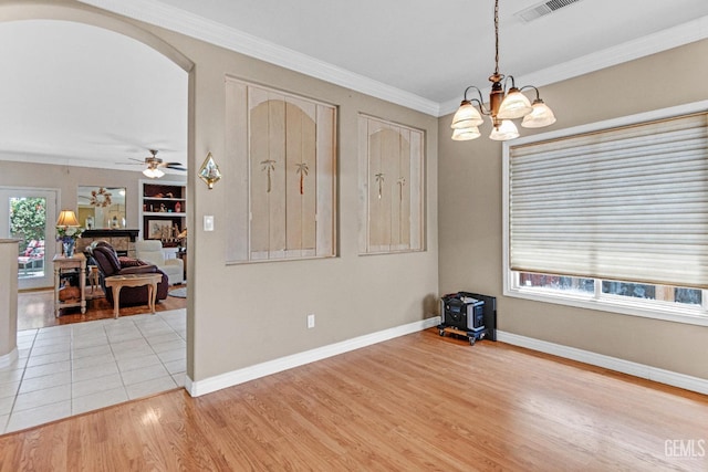 5510 Edge Water Ct, Bakersfield, CA 93312 - empty room with light wood-type flooring, a chandelier, a ceiling fan, ornamental molding, and arched walkways