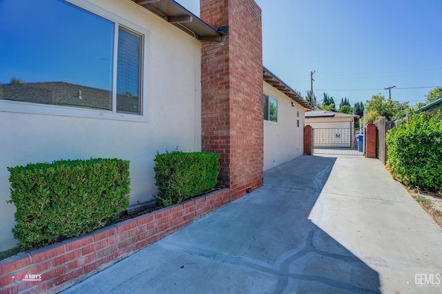 1825 Camino Primavera, Bakersfield, CA 93306 - view of side of property with stucco siding, a chimney, a gate, and a patio