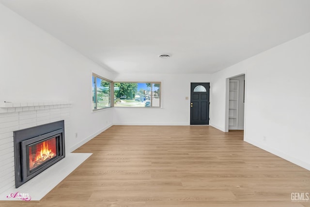 1825 Camino Primavera, Bakersfield, CA 93306 - unfurnished living room featuring a brick fireplace and light wood-style floors