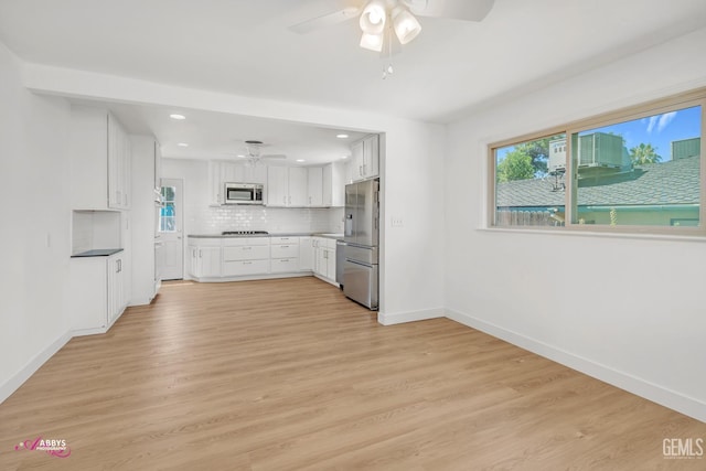 1825 Camino Primavera, Bakersfield, CA 93306 - kitchen featuring a ceiling fan, stainless steel appliances, white cabinets, backsplash, and light wood finished floors